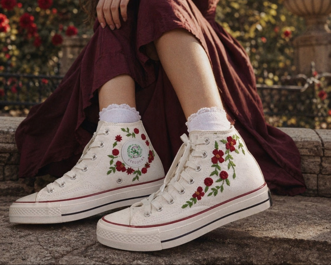 Woman wearing white high-top sneakers with floral embroidery in a garden setting